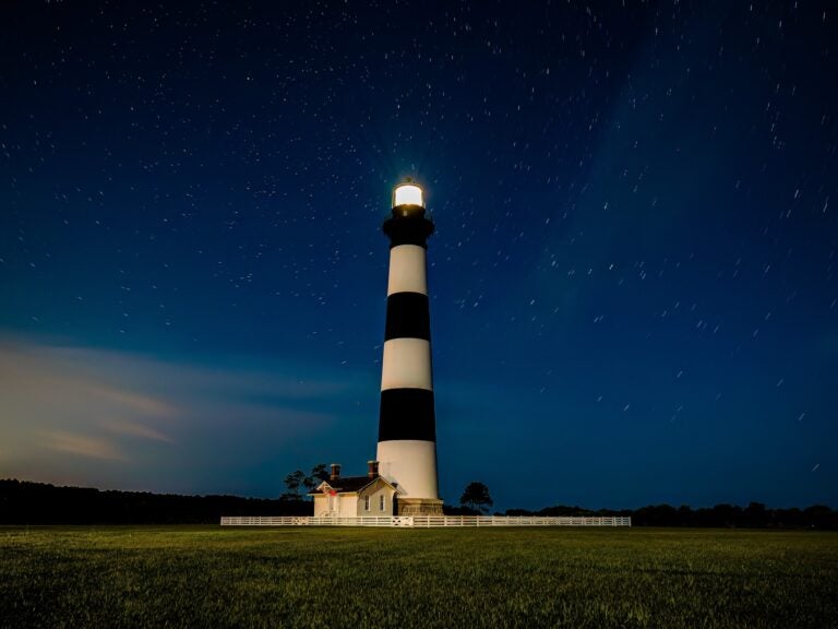 Lighthouse at night with stars in the sky
